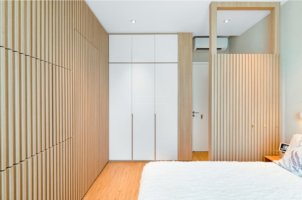 modern bedroom with wood flooring and feature wall