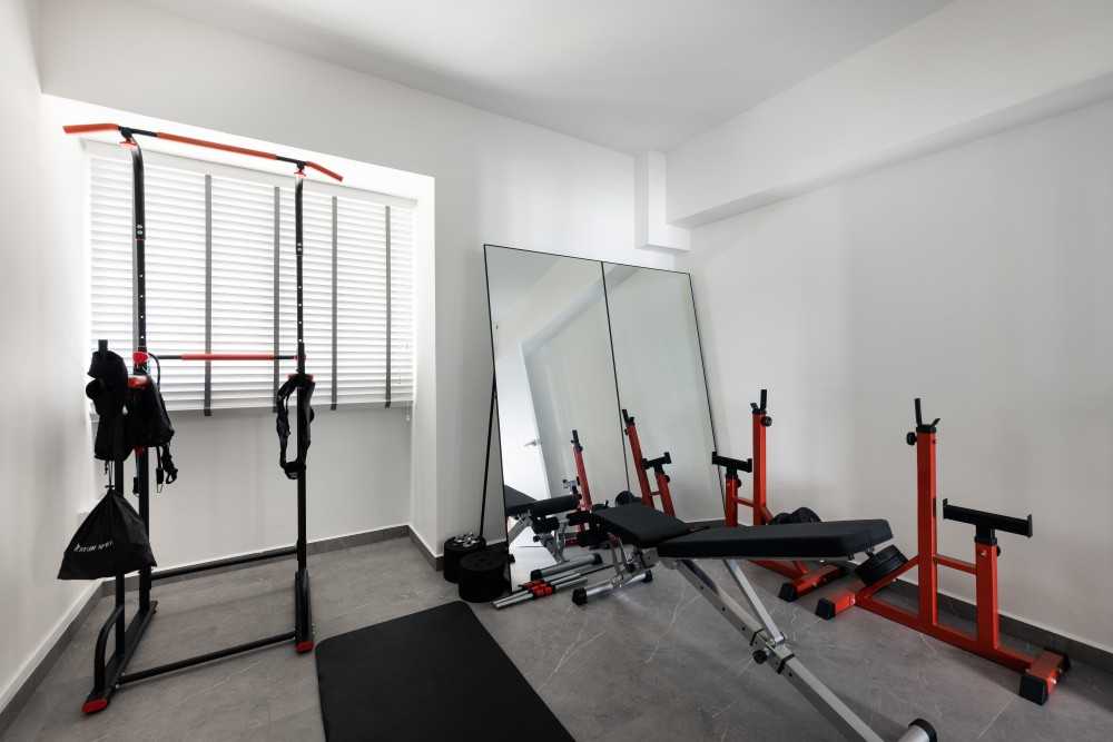 minimalist home gym with ceiling light and seating bench