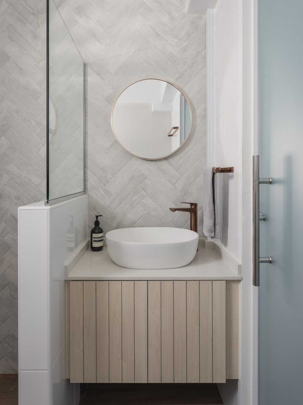 scandinavian bathroom with herringbone tiling and mirror