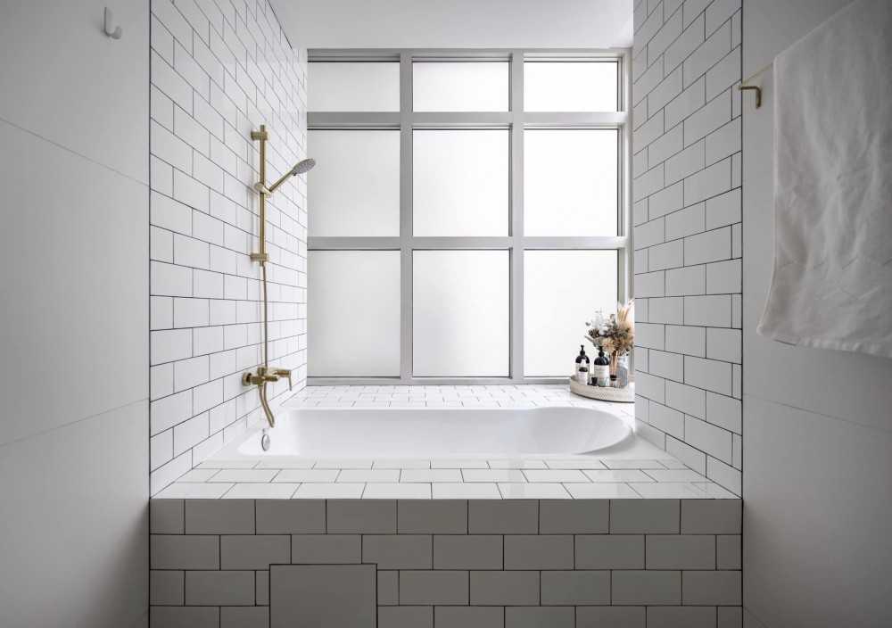 scandinavian bathroom with homogeneous tiles and mirror