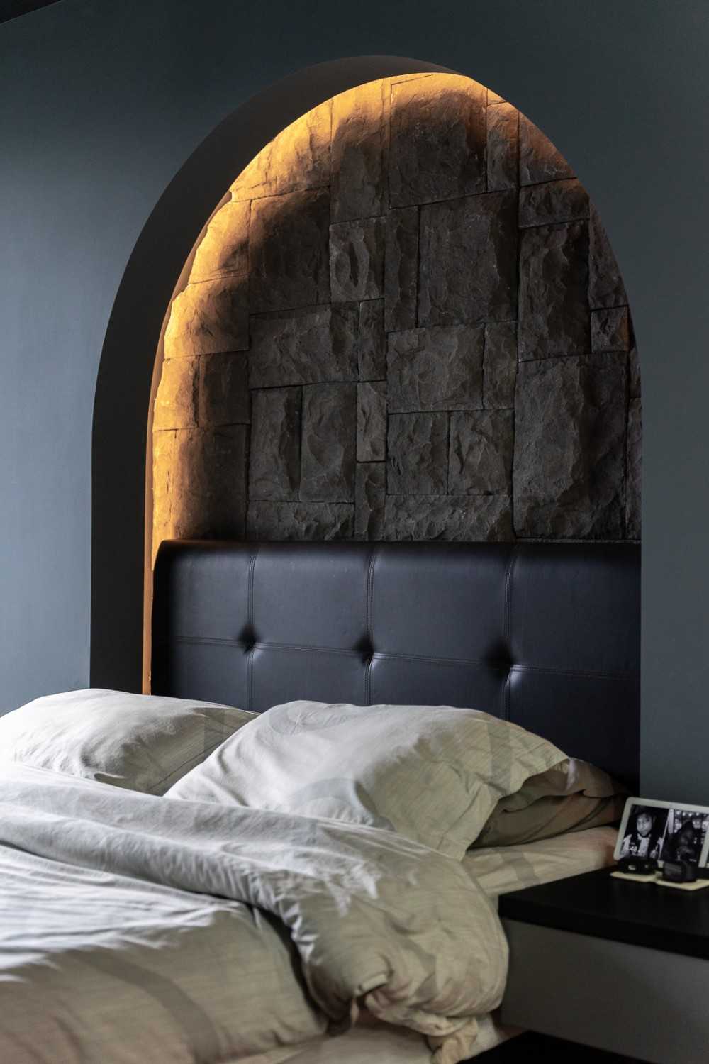 industrial bedroom with cove lighting and bedside table